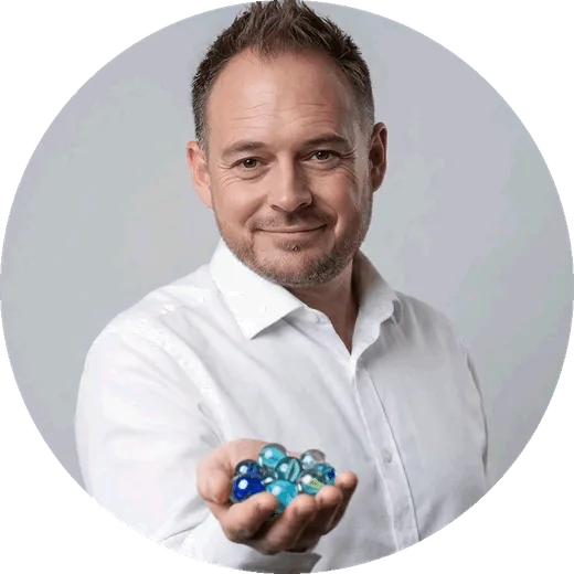 Duncan, founder of Digital Marbles Co., holding blue glass marbles