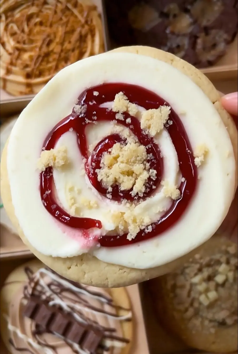 A Dipp'd cookie held above a box of iced cookies