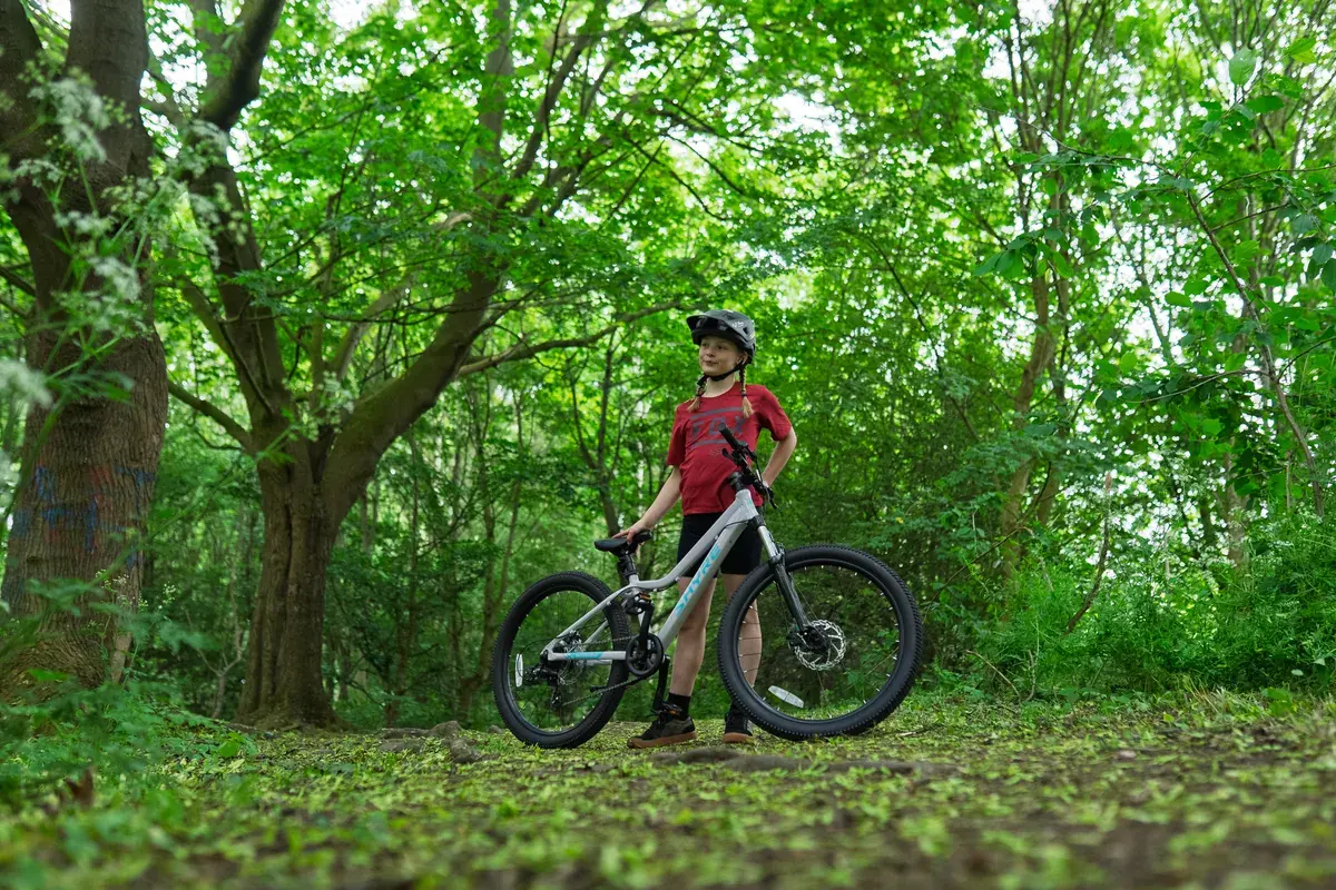 A young rider with a Shyre mountain bike in the woods